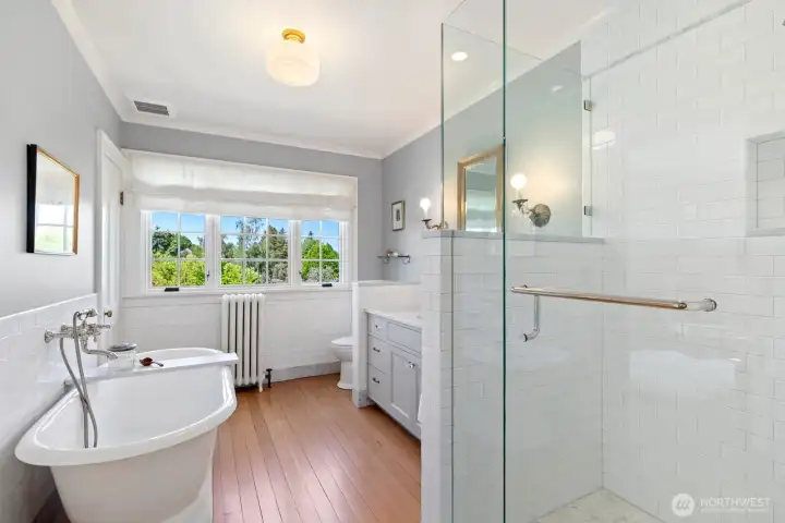 Primary bath offers shower and separate soaking tub with garden vista. Primary bath offers shower and separate soaking tub with garden vista.