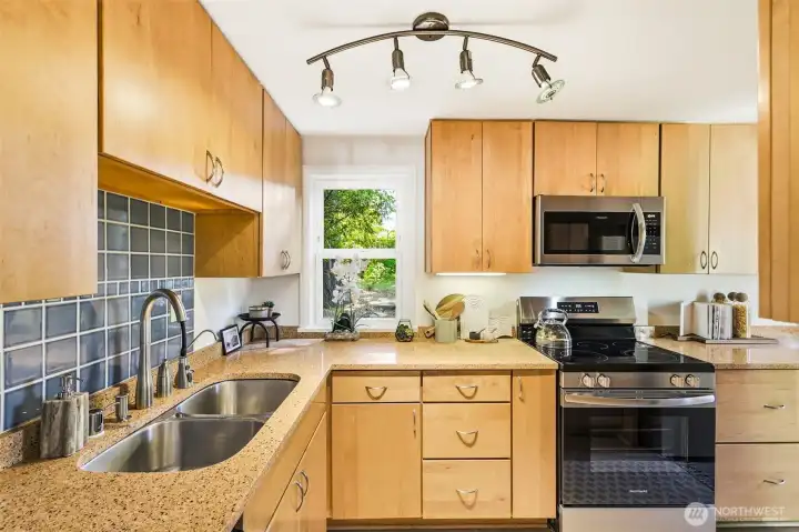 Kitchen with quartz counters, fresh flooring, and brand new appliances