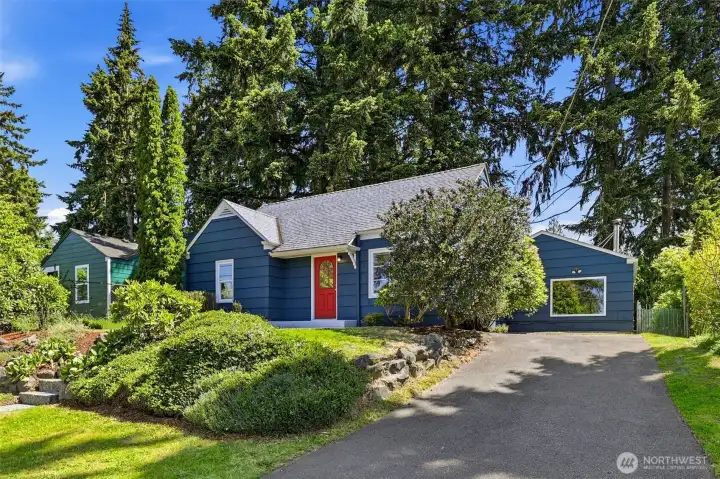 Welcoming front exterior with charming curb appeal and mature landscaping