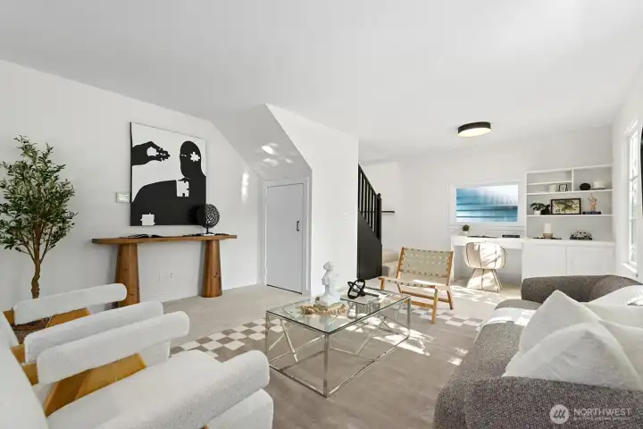 Living Room with stairs to 2nd floor and built in desk at far end of room Living Room with stairs to 2nd floor and built in desk at far end of room