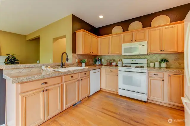 The kitchen has granite countertops, tile backsplash, and white appliances.  All appliances stay with the home.