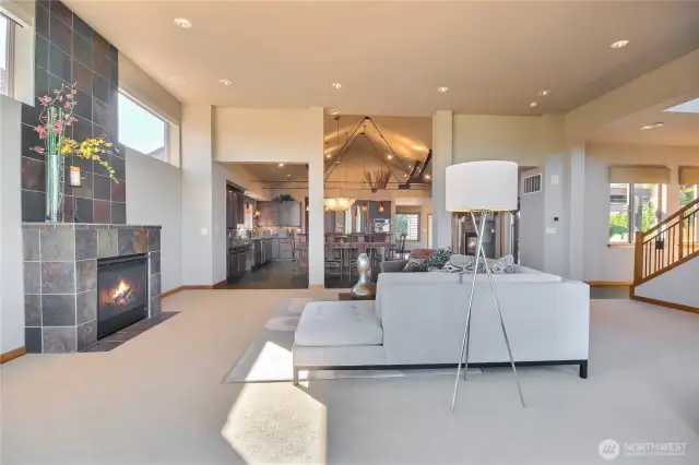Great room with gas fireplace looking into the kitchen and dining room