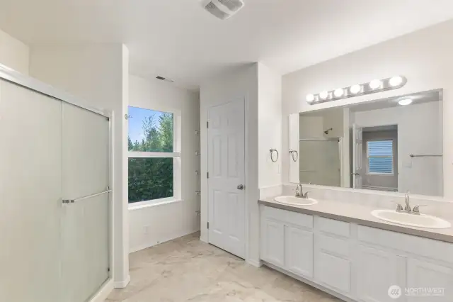 Primary ensuite bath with double vanity, soaking tub and separate shower