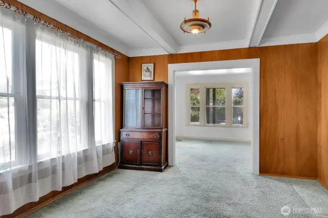 The dining room has a wall of windows and a vintage light fixture.