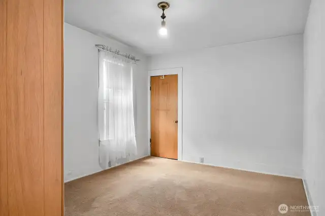 The main bedroom on the main floor with a window facing west.