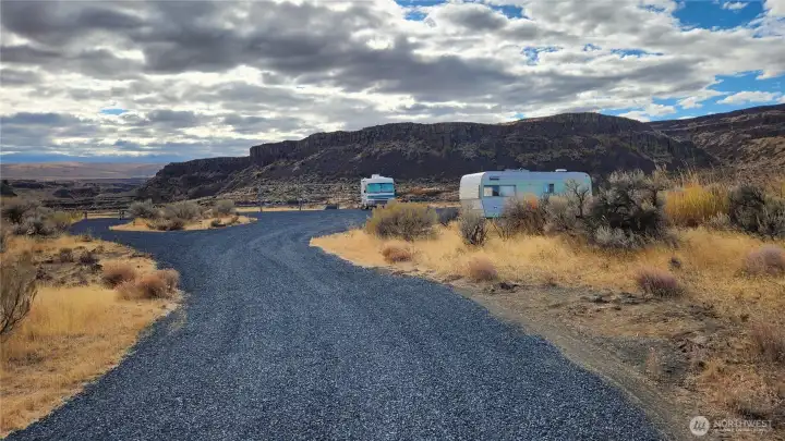Gravel circular driveway to camping area. RV & Trailer are included. (Trailer is a bonus sleeping area)