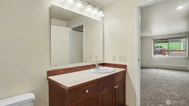 Centrally located full bath with more of the sleek countertops and warm cabinetry.