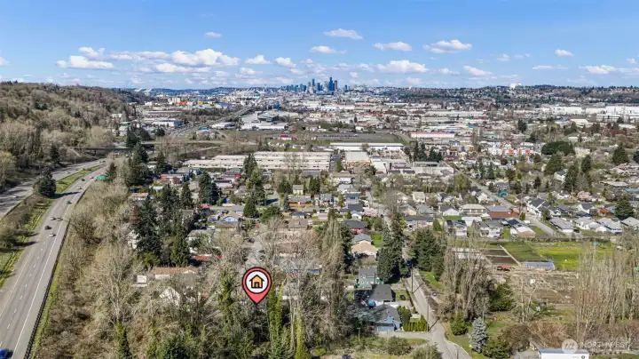 Seattle skyline ahead, Hwy 99 and 509 right there — 18 minutes to downtown. What the drone can't show: Good Voyage, Honor Mexicano, Loretta's, South Town Pie, and Little Jaye all within walking distance on 14th Ave S. South Park is the real thing.