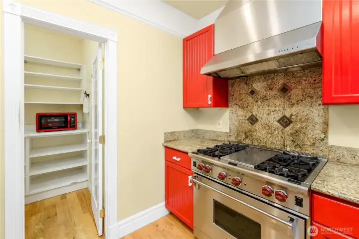 Designed for the home chef, this kitchen features a professional-grade WOLF gas range, granite countertops, stainless steel finishes, a spacious pantry, and abundant storage for effortless cooking and entertaining. Designed for the home chef, this kitchen features a professional-grade WOLF gas range, granite countertops, stainless steel finishes, a spacious pantry, and abundant storage for effortless cooking and entertaining.