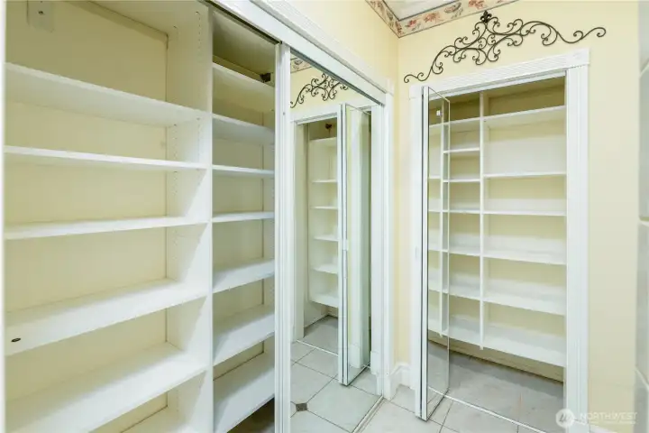 Exceptional built-in storage keeps everything beautifully organized with floor-to-ceiling shelving, mirrored closet doors, and dedicated space for linens, clothing, and everyday essentials. Exceptional built-in storage keeps everything beautifully organized with floor-to-ceiling shelving, mirrored closet doors, and dedicated space for linens, clothing, and everyday essentials.