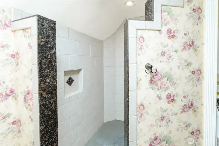 Spacious walk-in tiled shower with decorative granite accents, built-in shampoo niche, and an open design that blends timeless craftsmanship with everyday functionality. Spacious walk-in tiled shower with decorative granite accents, built-in shampoo niche, and an open design that blends timeless craftsmanship with everyday functionality.
