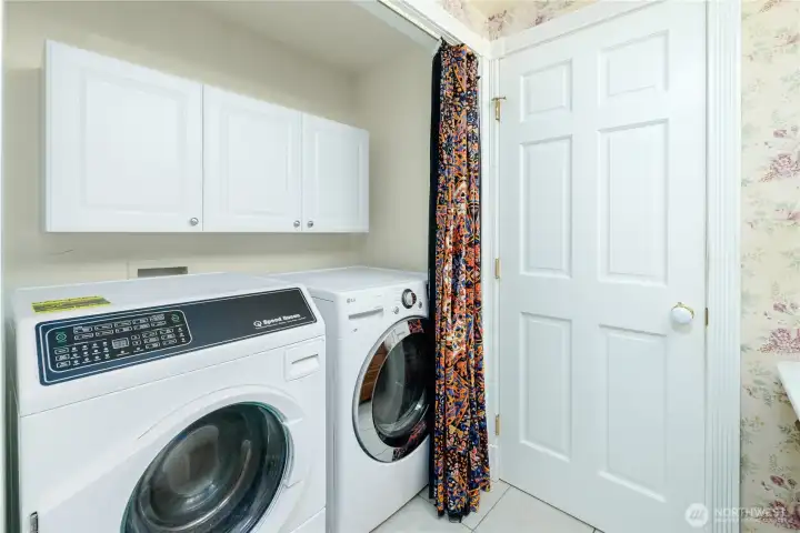 Convenient laundry area with upper storage cabinets, side-by-side washer and dryer, and direct access from the guest bath—designed to make everyday living both practical and efficient. Convenient laundry area with upper storage cabinets, side-by-side washer and dryer, and direct access from the guest bath—designed to make everyday living both practical and efficient.
