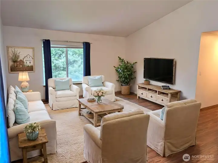 The living room feels extra spacious within its open floor plan and vaulted ceiling. Virtually staged to show versatility