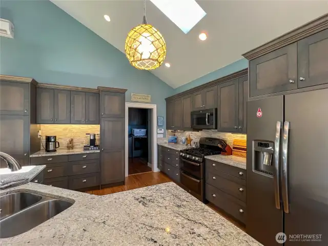 Kitchen features Alder wood cabinets with a grey washed finish, upgraded appliance with double ovens & cabinet depth side by side refrigerator and freezer.