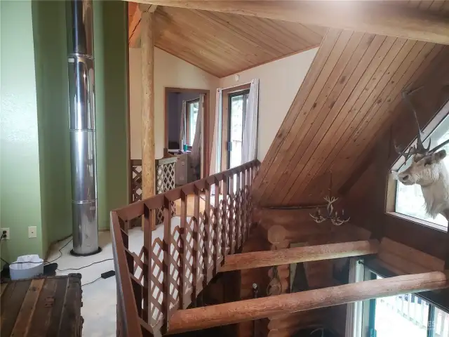 Upper level walkway to staircase, primary bedroom and upper deck