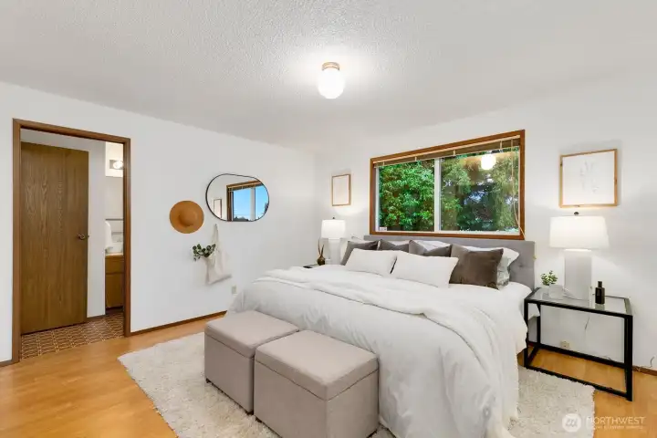 A view of the primary bedroom showing the pocket door that goes to the full bath.