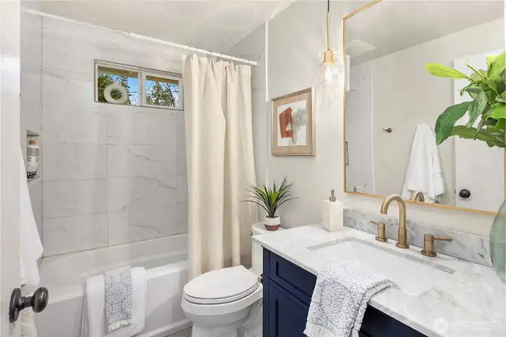 Updated bathroom with quartz countertops and tile shower/tub