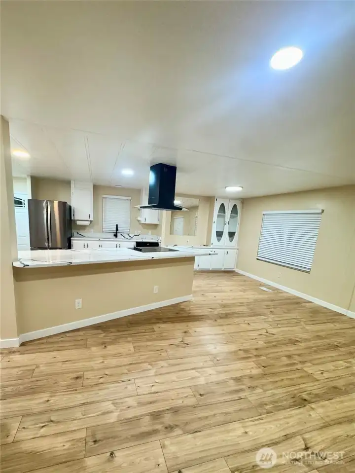 a zoomed out picture of the dinning and living room as well as the kitchen with drapes down