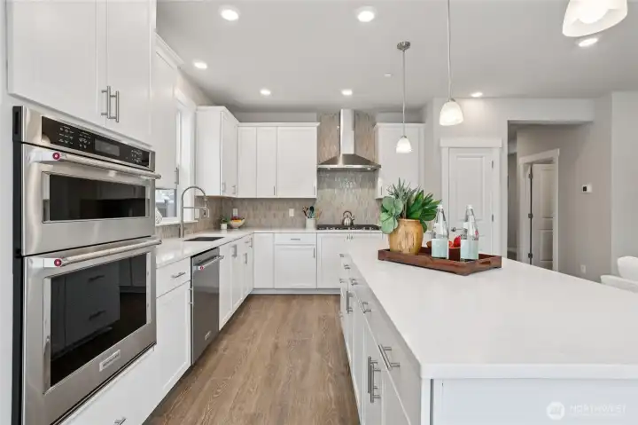 Bright kitchen with oversized island seating, crisp cabinetry, stainless steel appliances, and generous prep space. Bright kitchen with oversized island seating, crisp cabinetry, stainless steel appliances, and generous prep space.