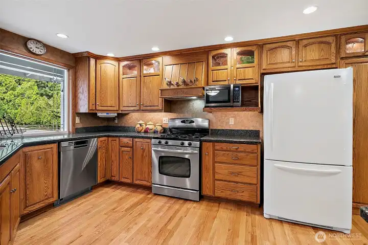 Custom Cabinets and Corian Counter Tops!   Lovely Beveled window overlooks front of property and lush landscaping.