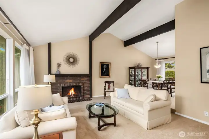Spacious, light filled formal living and dining rooms with cathedral ceilings, exposed beams, inviting fireplace and lots of tall windows that bring in great sunlight