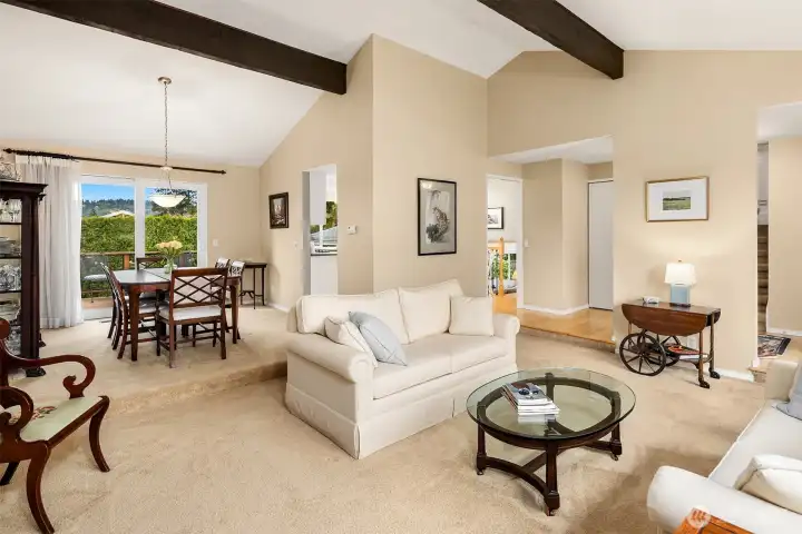 Spacious, light filled formal living and dining rooms with cathedral ceilings, exposed beams, inviting fireplace and lots of tall windows that bring in great sunlight