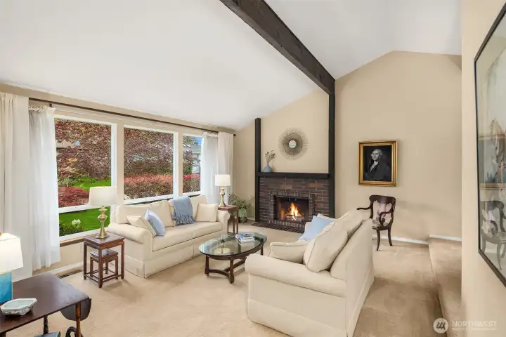 Spacious, light filled formal living and dining rooms with cathedral ceilings, exposed beams, inviting fireplace and lots of tall windows that bring in great sunlight