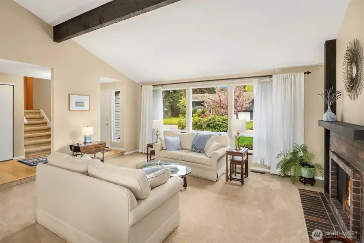 Spacious, light filled formal living and dining rooms with cathedral ceilings, exposed beams, inviting fireplace and lots of tall windows that bring in great sunlight