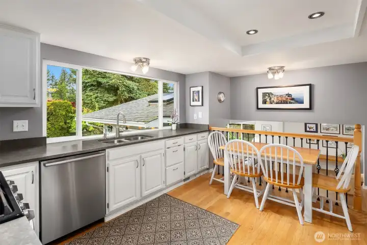 Beautifully updated kitchen with all stainless steel appliances, quartz counter tops, overlooking the peaceful backyard and access to the huge family room on the lower level