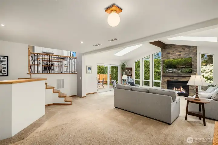 Huge family room with cathedral ceilings, skylights, beautiful gas fireplace with stone surround and direct access to the lower deck and backyard
