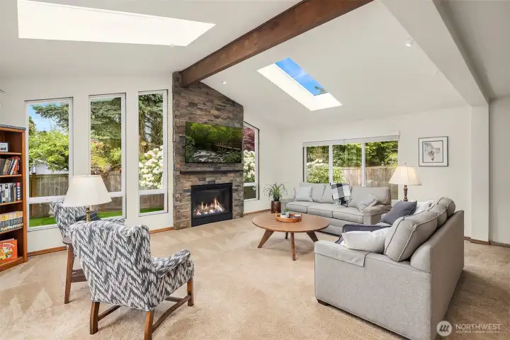 Huge family room with cathedral ceilings, skylights, beautiful gas fireplace with stone surround and direct access to the lower deck and backyard