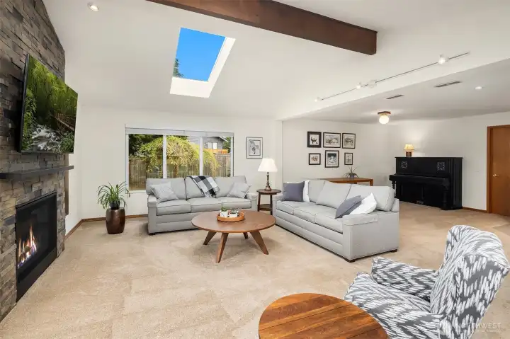 Huge family room with cathedral ceilings, skylights, beautiful gas fireplace with stone surround and direct access to the lower deck and backyard