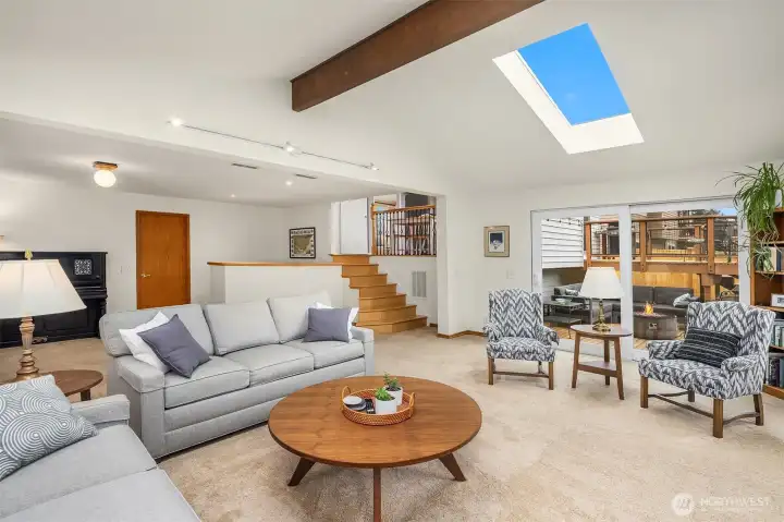 Huge family room with cathedral ceilings, skylights, beautiful gas fireplace with stone surround and direct access to the lower deck and backyard