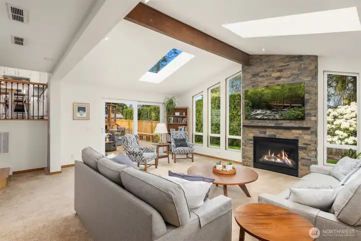 Huge family room with cathedral ceilings, skylights, beautiful gas fireplace with stone surround and direct access to the lower deck and backyard