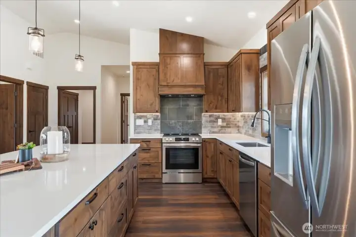 Quartz counters and SS appliances + knotty alder custom cabinetry