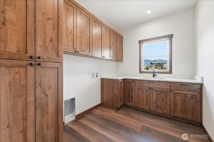Laundry with custom cabinetry folding table plus sink