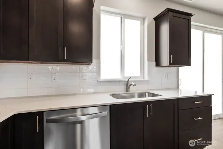 Enjoy the window over your kitchen sink;  Bakerview Huntington has light gray painted cabinetry.  Other fiinishes will vary.