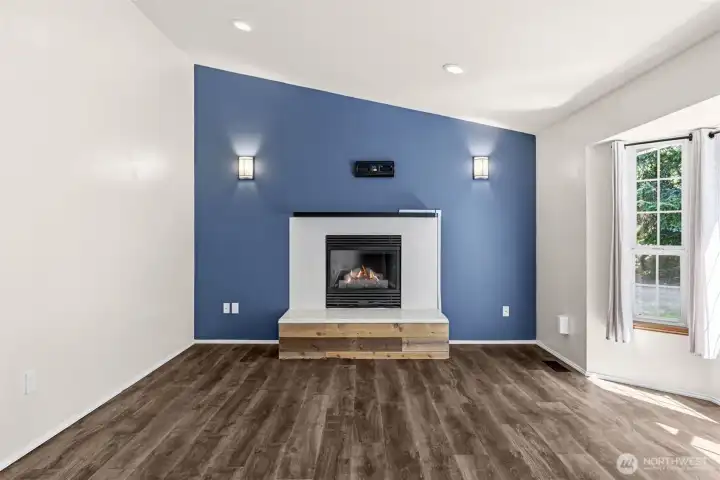 Freshlly painted living room with a cozy gas fireplace and bay windows is full of light and has plenty of room for your furnishings and relaxation.