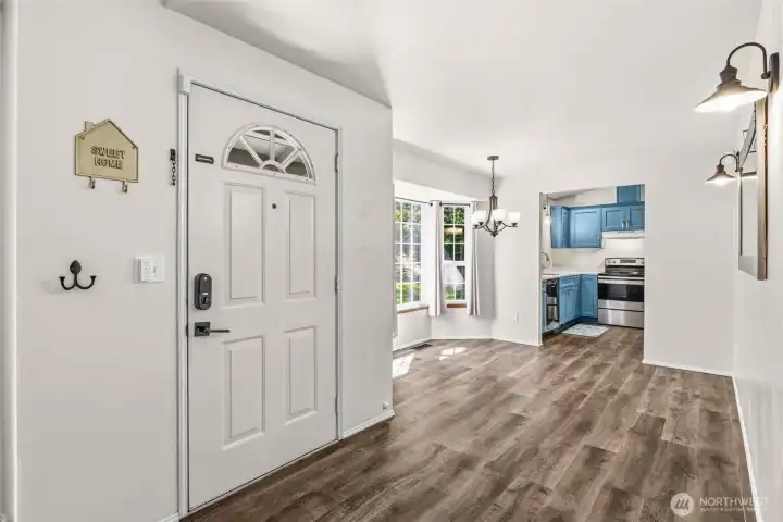 From the entry looking into the dining area with bay windows and into the kitchen.