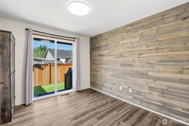 Bedroom 3 with custom woodwork on wall and slider to back yard