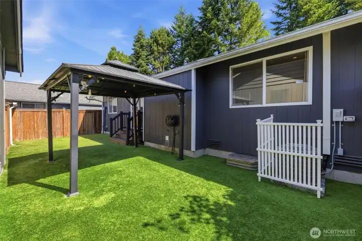 The private back yard boasts easy to care for no-mow lawn, a covered gazebo, AC unit and storage.