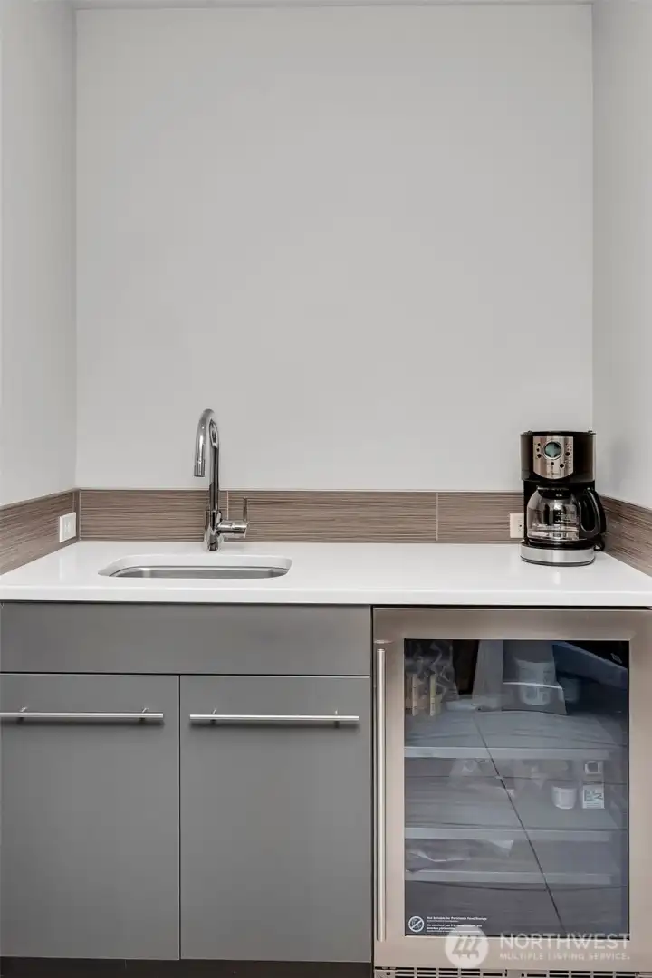 A nice entertaining set up downstairs with sink and mini fridge. Perfect for the drinks and snacks during game or movie nights A nice entertaining set up downstairs with sink and mini fridge. Perfect for the drinks and snacks during game or movie nights