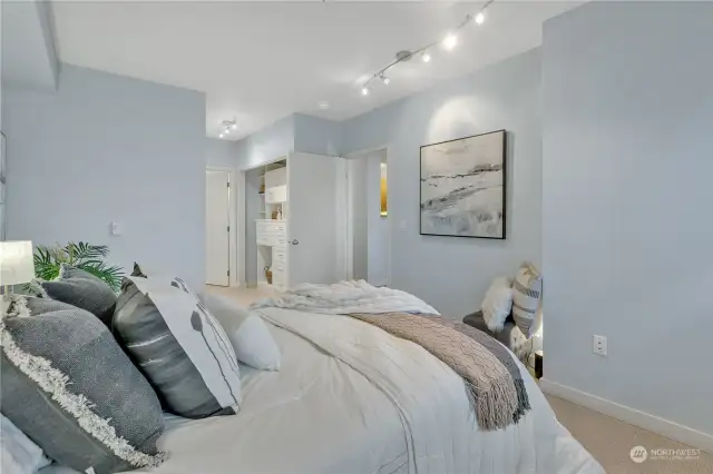 Generous primary bedroom in serene, neutral tones. The niche or alcove under the picture on the far wall would accommodate a dresser nicely.