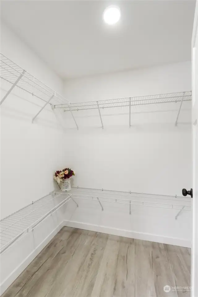 Wire shelving wraps around three walls and provides ample space for your long clothing items just behind the closet door (not in view).