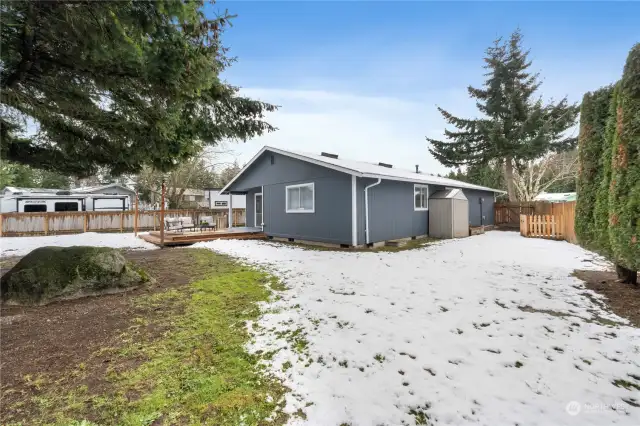 Full West side yard highlighting gate access, planting beds that are across from each other and a storage shed that will convey with property.