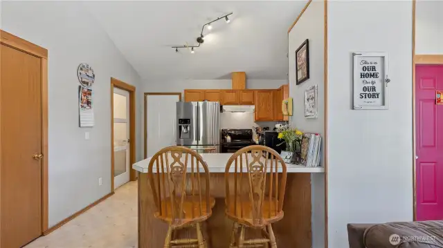 Kitchen with eating counter, walk-in pantry on the left, then utility room and the white door to the 1 car attached garage.