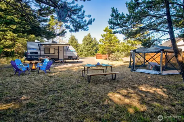No need to rough it! This lot is ready with water, sewer, and electric hookups, a privacy fence, trees on three sides, and a durable gravel driveway.