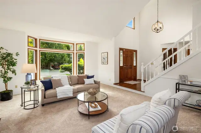 Formal living room with a large bay window and vaulted ceilings