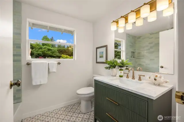 Brand new hall bath features stunning tile and a beautiful cabinet, new  lighting, faucet, countertops and toilet.