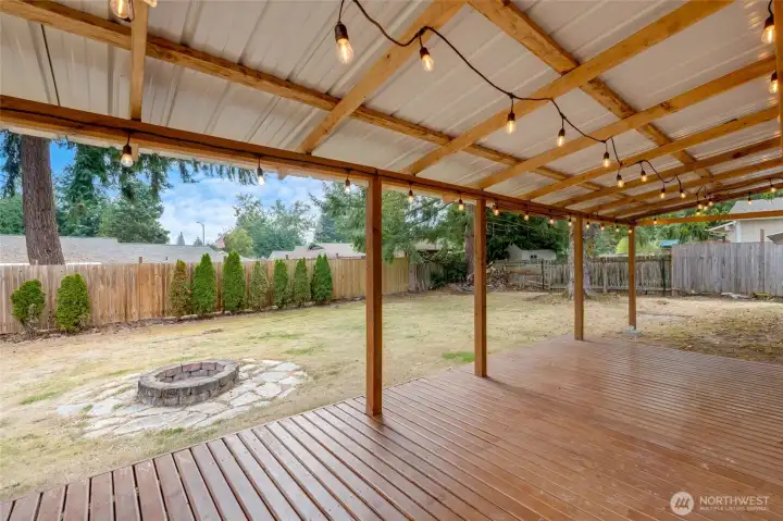 Backyard oasis with covered patio, fully fenced, fire pit and raised beds.